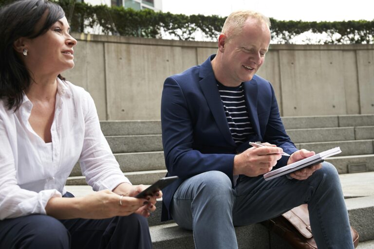 A man and woman engage in a work-related discussion outdoors in London.